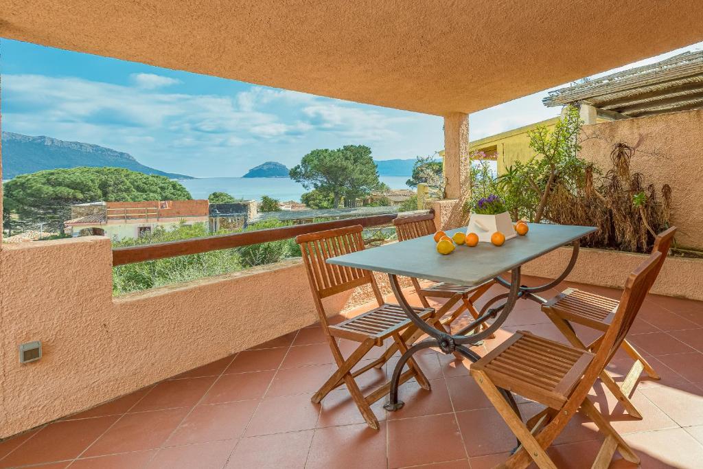 a table and chairs on a balcony with a view at Erica Piano Terra & Erica Primo Piano in Golfo Aranci