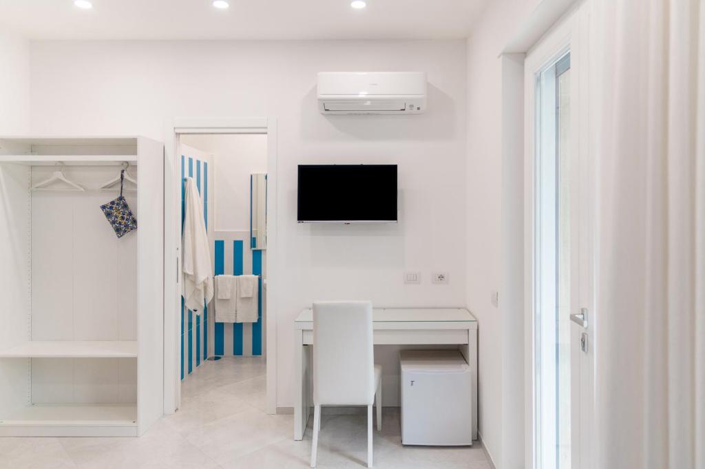 biały pokój ze stołem i telewizorem na ścianie w obiekcie Blue Coral Suite B&B w Sorrento