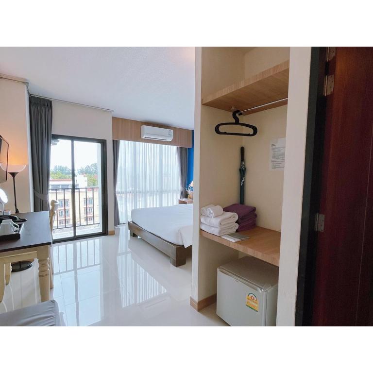 a hotel room with a bed and a desk at The Sixteenth Naiyang Beach Hotel SHA Plus in Nai Yang Beach