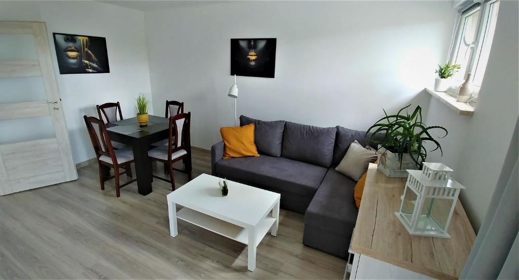uma sala de estar com um sofá e uma mesa em M&M Suwałki Centrum em Suwałki