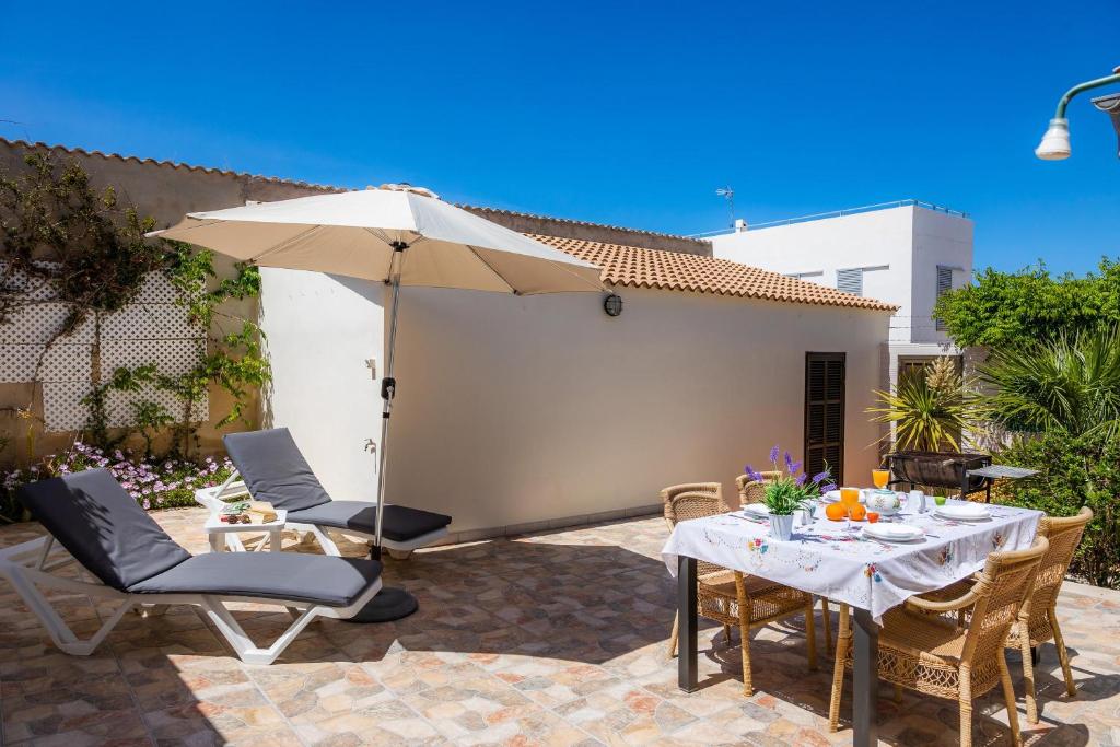 eine Terrasse mit Tisch und Sonnenschirm in der Unterkunft Casa Voramar Son Serra Beach in Son Serra de Marina