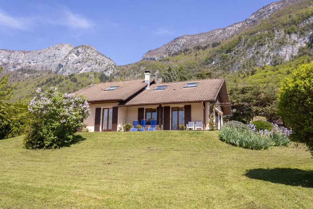 a house on a hill with mountains in the background at MAISON CHARLOTTE - Vue lac et à 5min des plages! in Veyrier-du-Lac