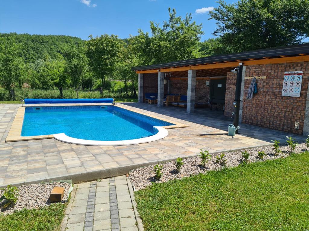 una piscina con patio y una casa en Holiday Home Faruk, en Račić