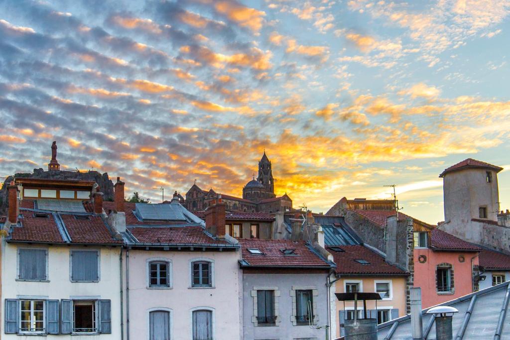 een uitzicht op een stad met een bewolkte lucht bij Gîte du rempart avec Balnéo, Garage, 2 SDB 2WC vue sur les monuments in Le Puy en Velay