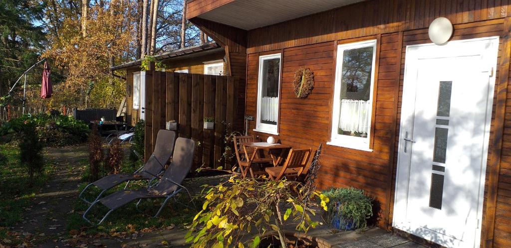 a cabin with a table and chairs outside of it at Bungalow am Donnerberg in Sewekow in Sewekow