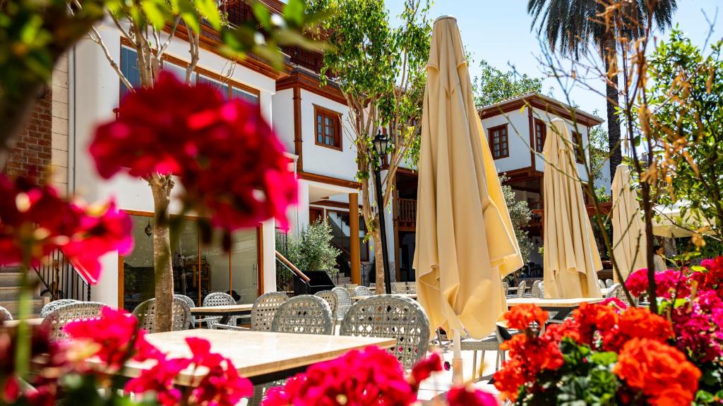 una mesa y sillas con sombrillas y flores en WOO Town Suites, en Antalya