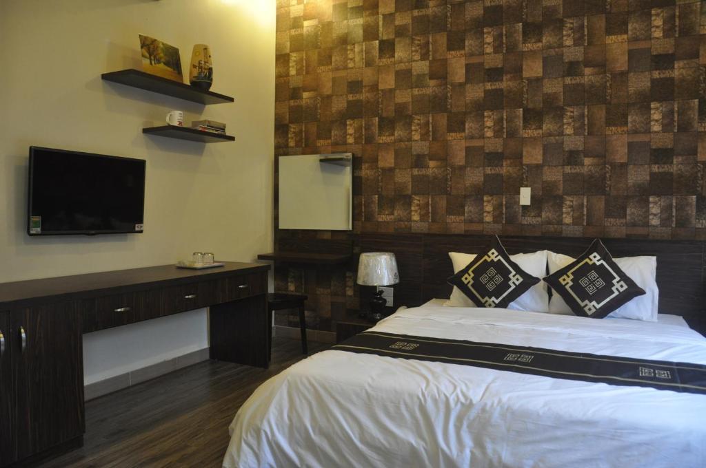 a bedroom with a bed and a flat screen tv at Rose Hotel in Hai Phong