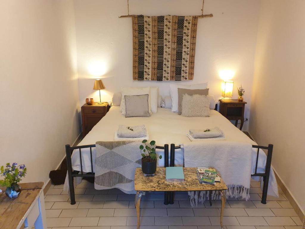 een slaapkamer met een groot bed en een tafel bij B&B Maison Juves Planchez Anost Lac des Settons in Planchez