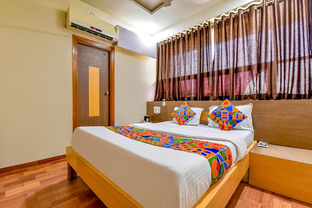 - une chambre avec un grand lit et une fenêtre dans l'établissement FabExpress Relax Inn, à Sarkhej