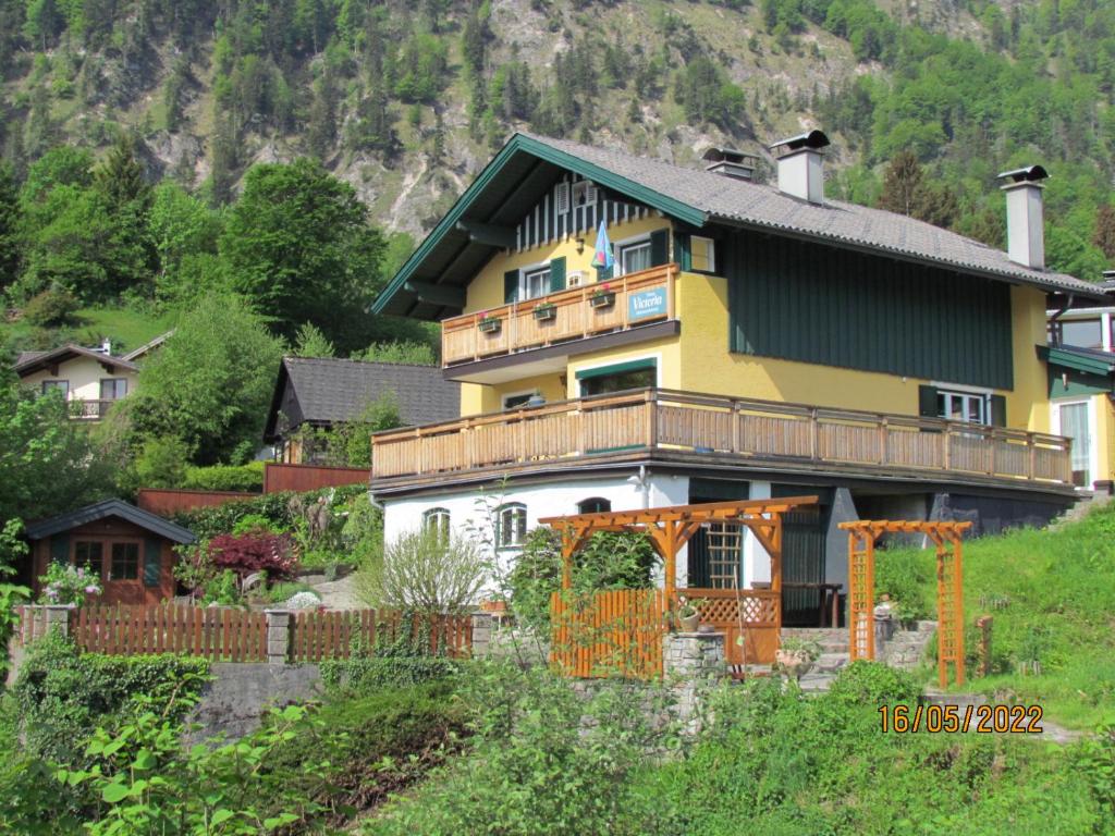 een groot geel en wit huis op een heuvel bij Haus Victoria in Sankt Gilgen