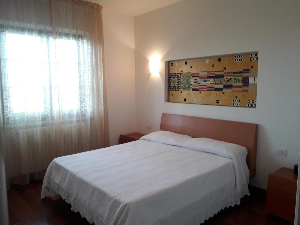 a bedroom with a white bed and a window at Villino Sabina in Civitella del Tronto