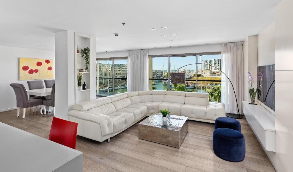 un soggiorno con divano bianco e tavolo di Water Front Luxury Family Apartment a Herzelia