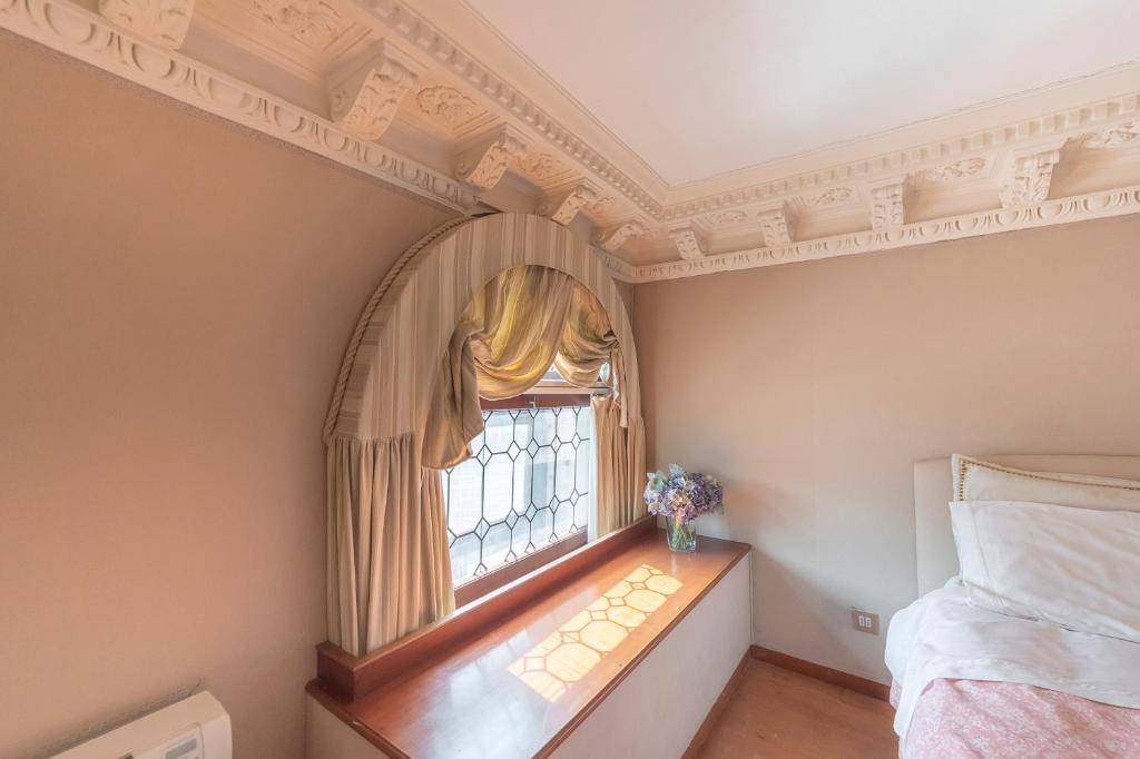 een slaapkamer met een raam en een bed erin bij Canal Grande Suite in Venetië