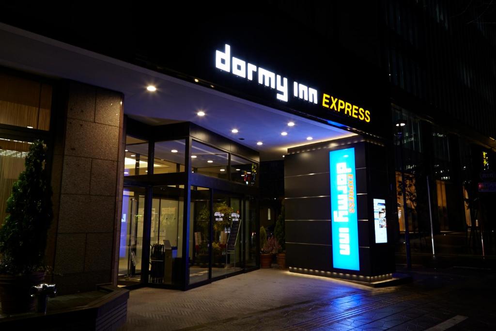 um edifício com uma placa que lê entrada Inn Express em Dormy Inn Express Sendai Hirose Dori em Sendai