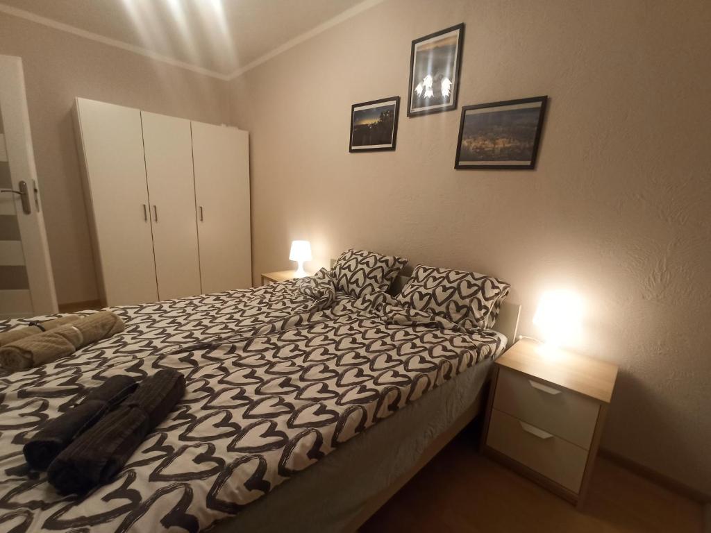 a bedroom with a bed with a black and white comforter at Apartament za rogiem Papierni in Duszniki Zdrój
