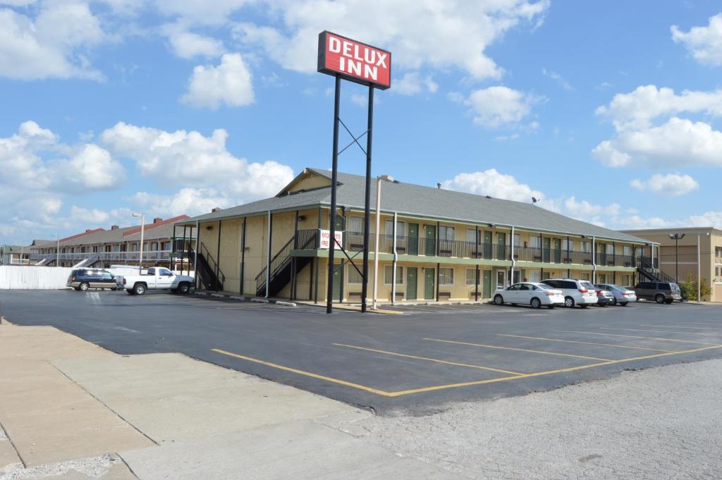 a sign in a parking lot in front of a hotel at Delux Inn Tulsa in Tulsa