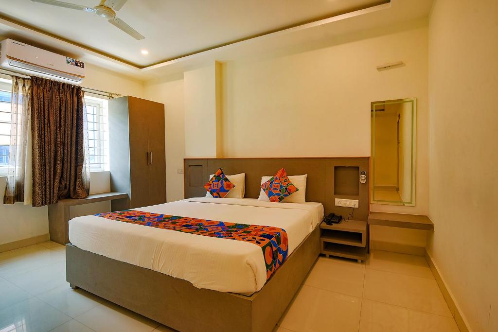 1 dormitorio con 1 cama grande y TV en FabHotel Champion Gateway, en Bangalore