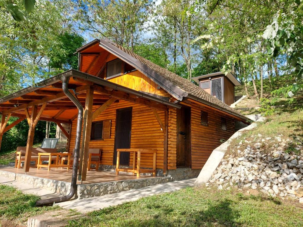 Cabaña de madera con porche y comedor en Vikendica, en Erdevik