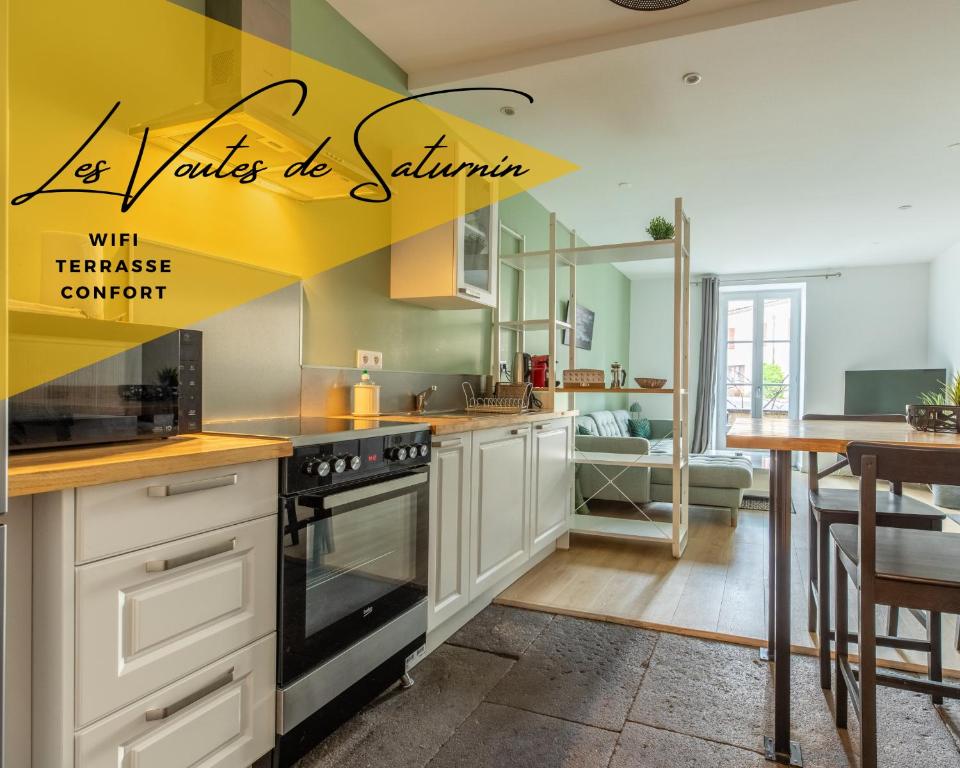 a kitchen with white cabinets and a yellow wall at LES VOÛTES DE SATURNIN in Saint-Saturnin