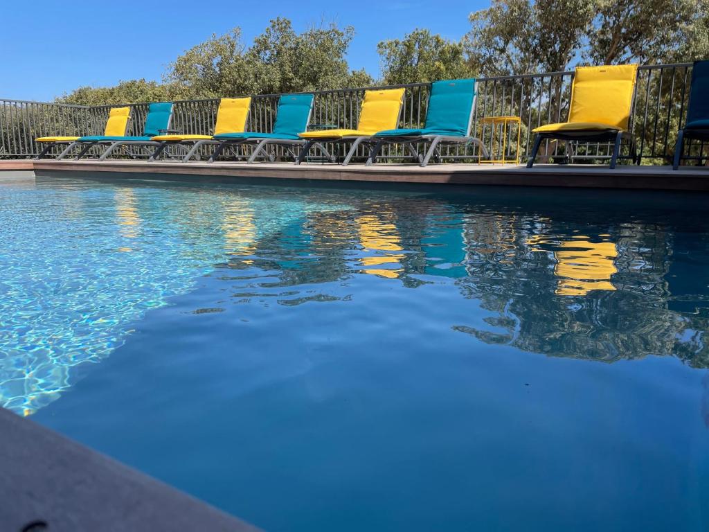a row of chairs sitting next to a swimming pool at Case Di A Cappana-Villa CARLA in Bonifacio