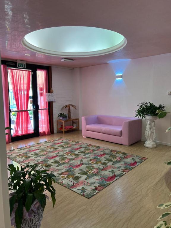 a living room with a pink couch and a rug at Hotel San Marco in Lido di Jesolo