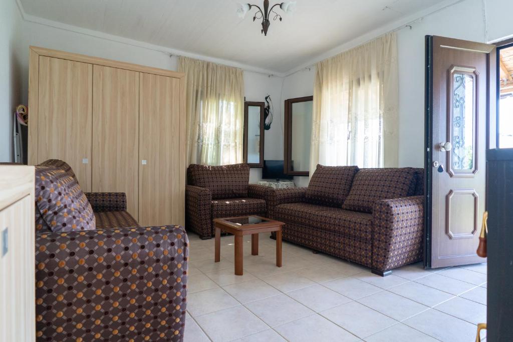 sala de estar con sofás y mesa en Pelion house with stunning view to relax, en Vizítsa