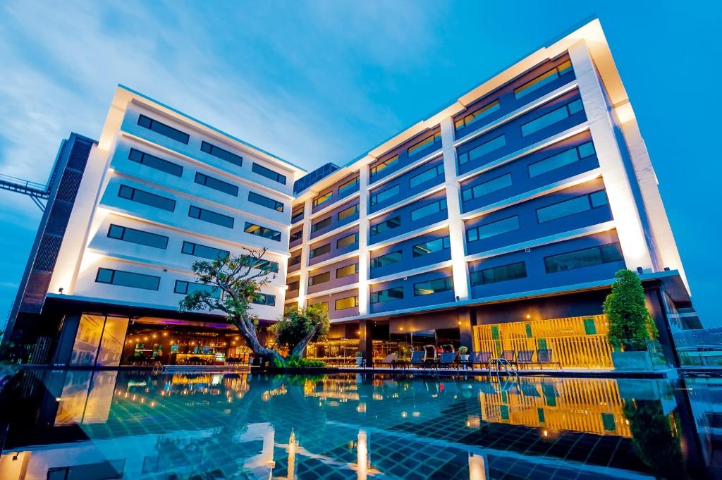 DARA Hotel - SHA Plus في فوكيت تاون: مبنى كبير أمامه مسبح