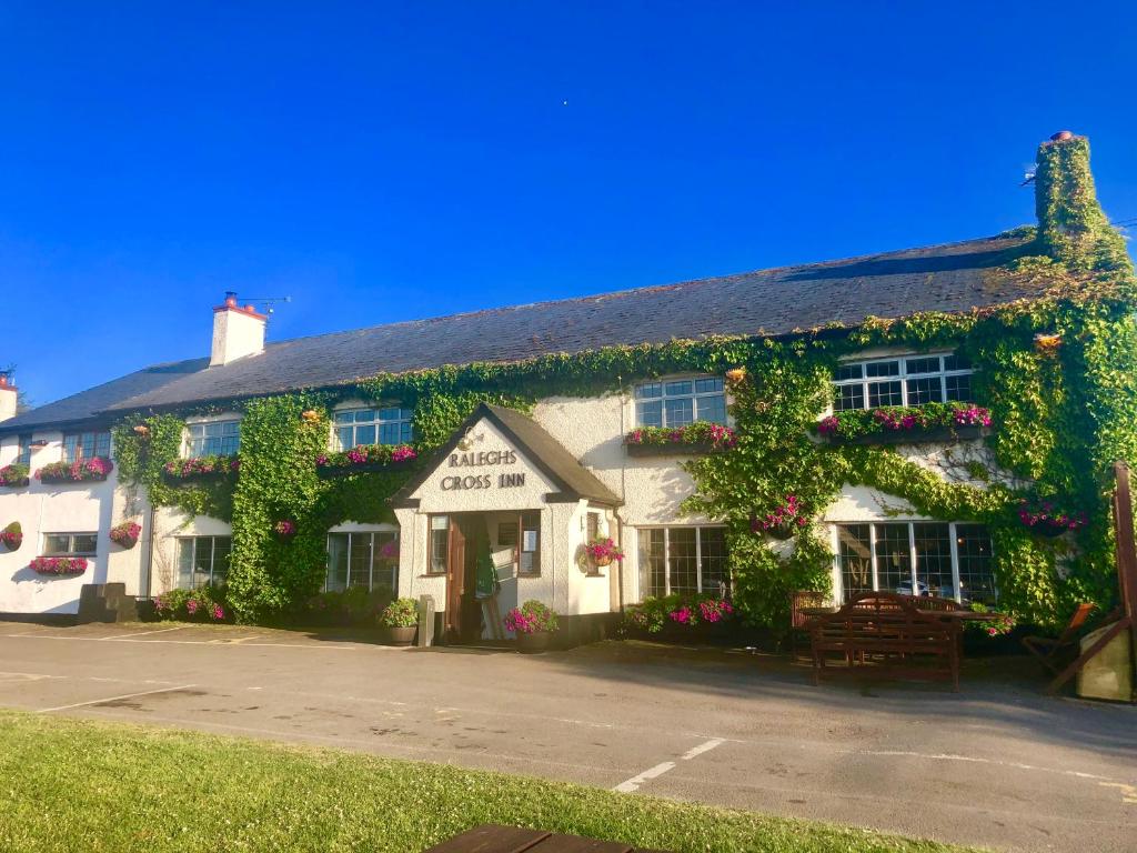 a large white building with flowers on it at Raleghs Cross Inn in Watchet