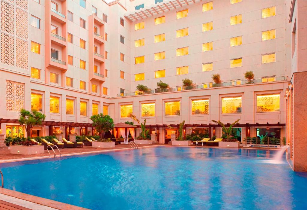 a hotel swimming pool in front of a building at Lemon Tree Premier, Delhi Airport in New Delhi