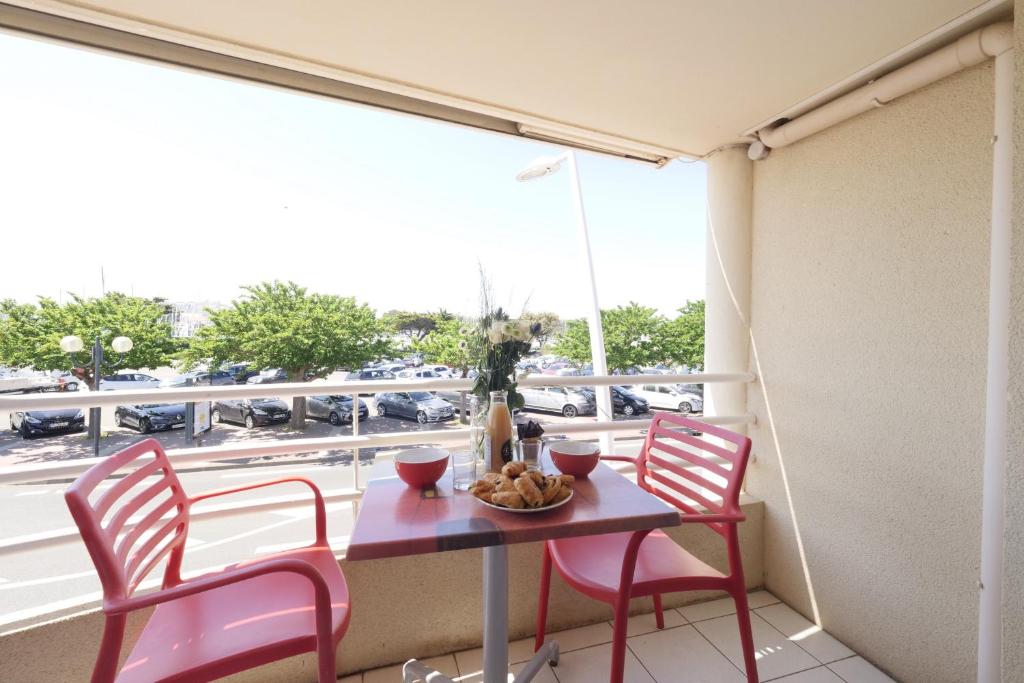 a table and chairs on a balcony with a view of a street at Un appartement sur la marina de St-Gilles in Saint-Gilles-Croix-de-Vie