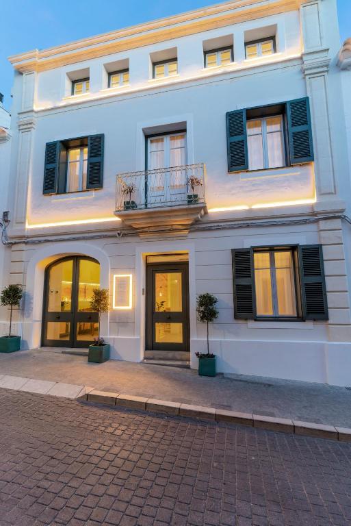 a white building with windows and a balcony at Hotel S'Antiga Adults Only in Es Mercadal