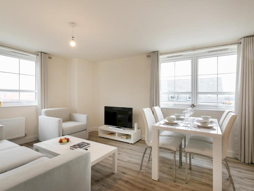 a white living room with a table and a tv at Pass the Keys Stunning 2 bed Apartment with free onsite parking in Nottingham