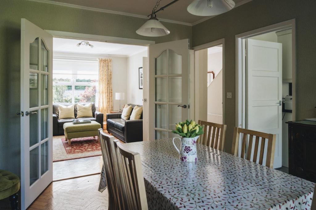 a kitchen with a table and a living room at Hope Cottage in Portrush