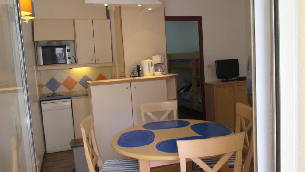 サン・ラファエルにあるPromenade des Bains Apartmentの小さなキッチン(テーブル、椅子付)