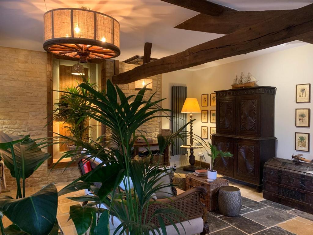 a living room with a large plant and a ceiling at Dovecote Cotswold Cottages in Chipping Norton