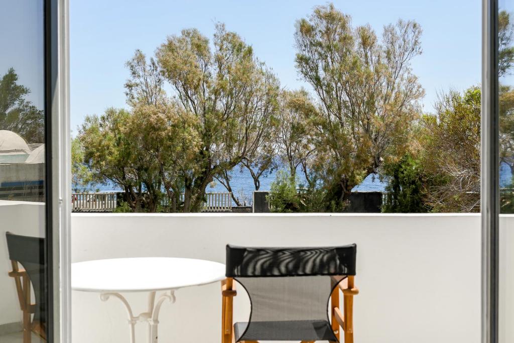 a table and chairs on a balcony with a view of the water at Exi Sea Side Suites in Perissa