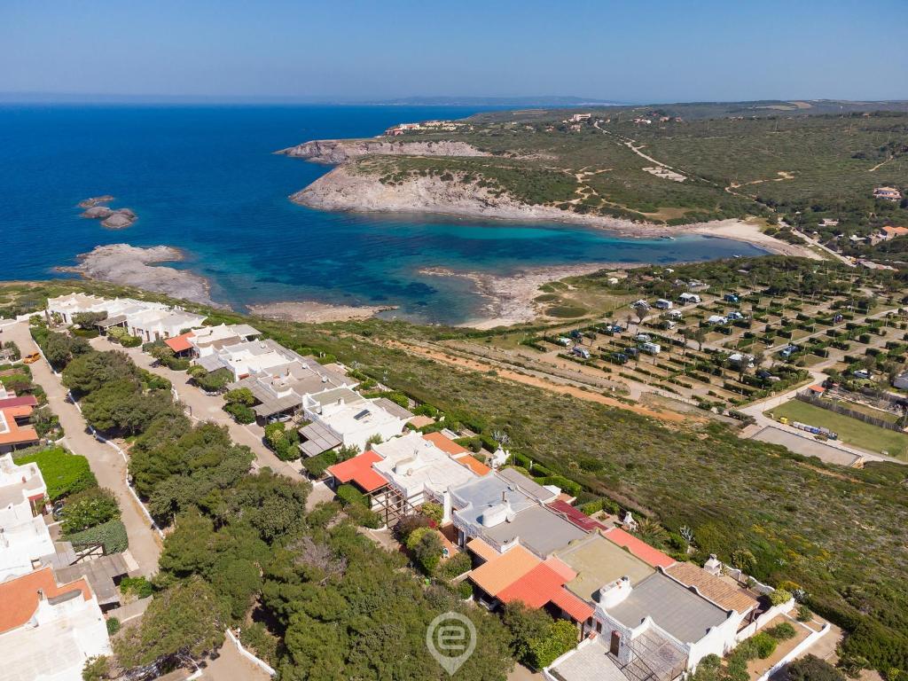 uma vista aérea de uma praia com casas e o oceano em House Eleonora - Villaggio Polifemo em Cala Sapone