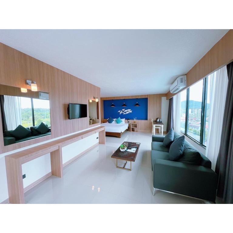 a living room with a couch and a tv at The Sixteenth Naiyang Beach Hotel SHA Plus in Nai Yang Beach
