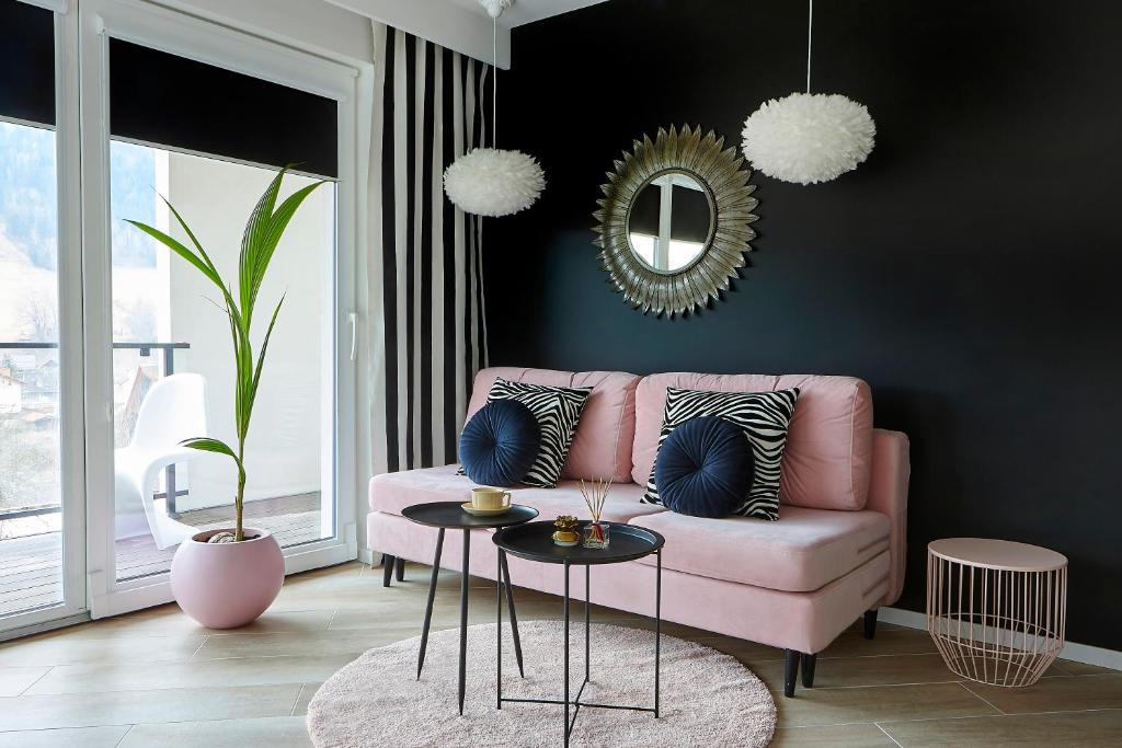 a living room with a pink couch and a mirror at Apartament Sun House 60 z prywatną SAUNĄ KOMINKIEM i widokiem na SKRZYCZNE in Szczyrk