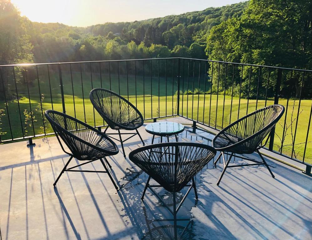 eine Terrasse mit 4 Stühlen und einem Tisch auf einer Terrasse in der Unterkunft La conciergerie in Namur