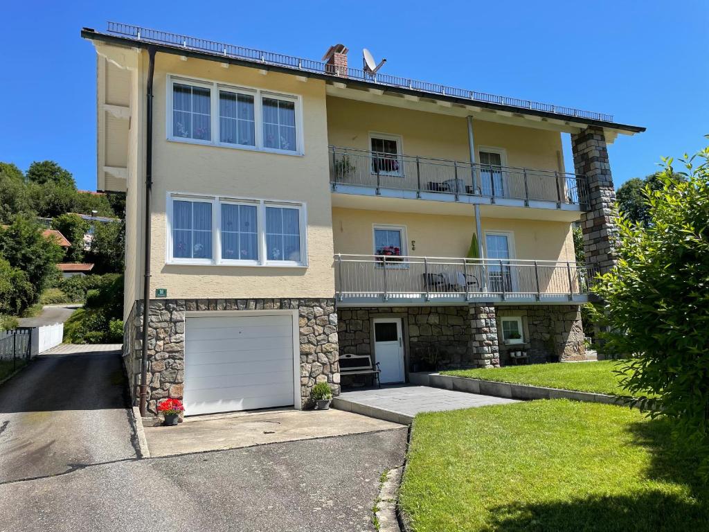 une grande maison jaune avec un garage blanc dans l'établissement Haus Beate, FeWo im Bienenparadies, à Kirchberg