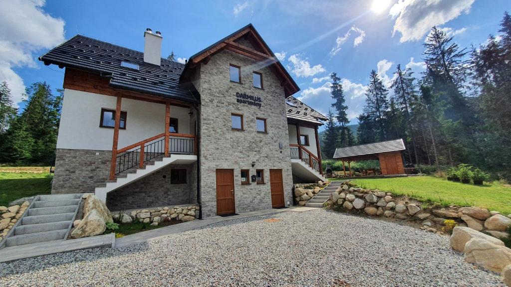 a house with a staircase on the side of it at Darmilus apartmány in Demanovska Dolina