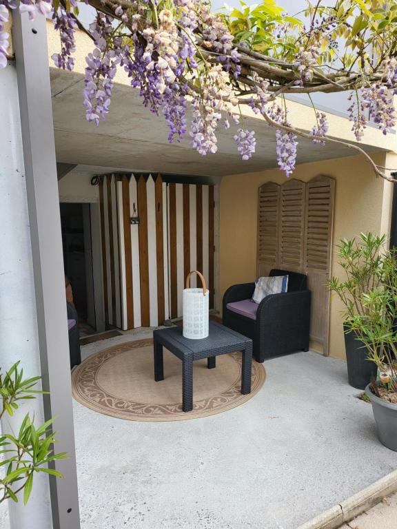 um pátio com uma mesa e um sofá em T2 terrasse de charme à Rochebonne 400 m plage em Saint Malo