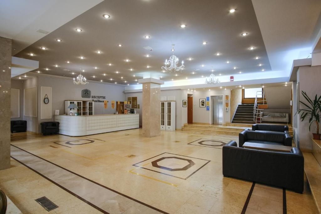 un vestíbulo con sofás y una escalera en un edificio en Hotel Rusca, en Hunedoara