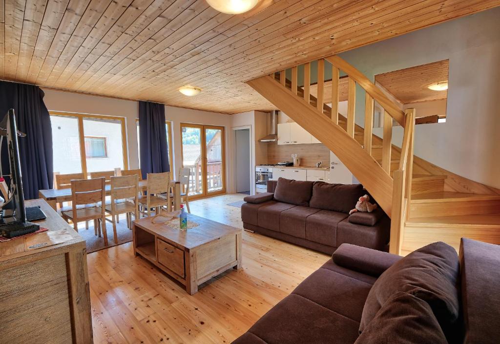 a living room with a couch and a staircase at Jacobs Resort House Kranjska Gora in Kranjska Gora