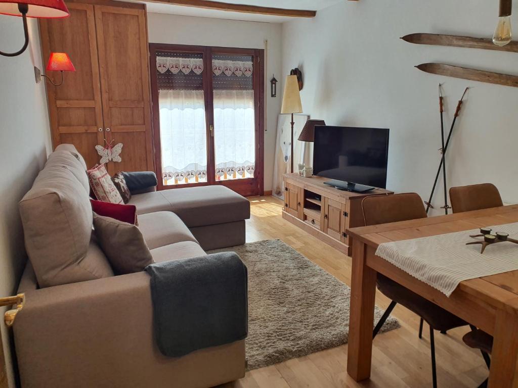 uma sala de estar com um sofá e uma televisão em ES CÒVES em Vielha