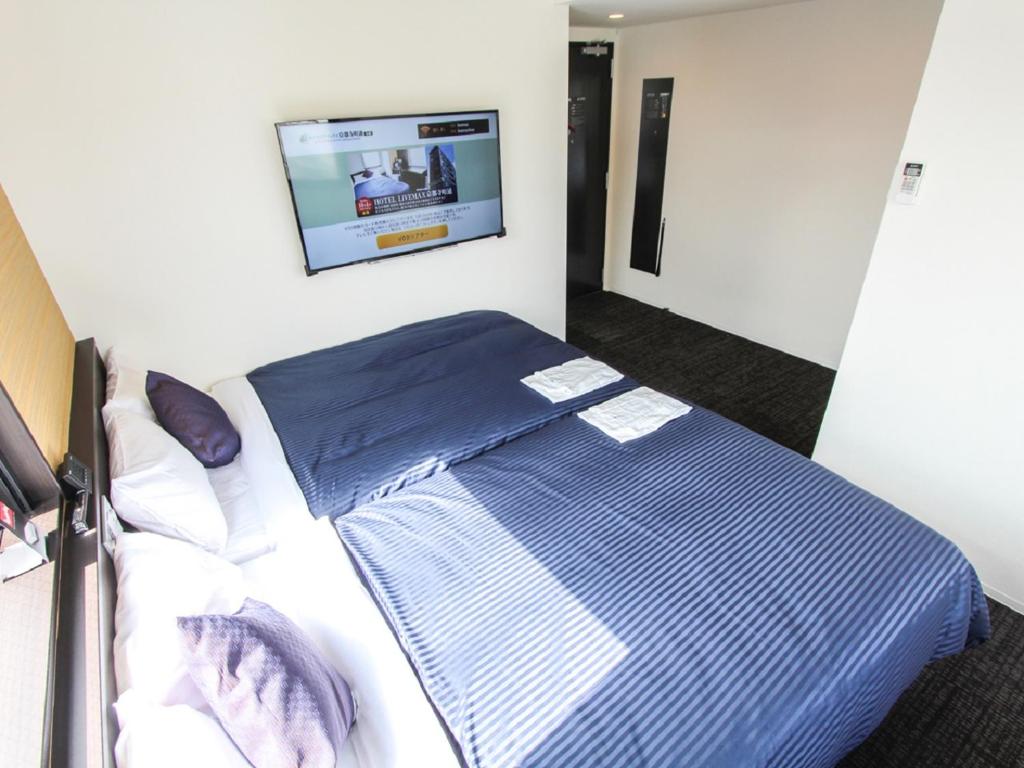 Postel nebo postele na pokoji v ubytování HOTEL LiVEMAX Kyoto Teramachidori
