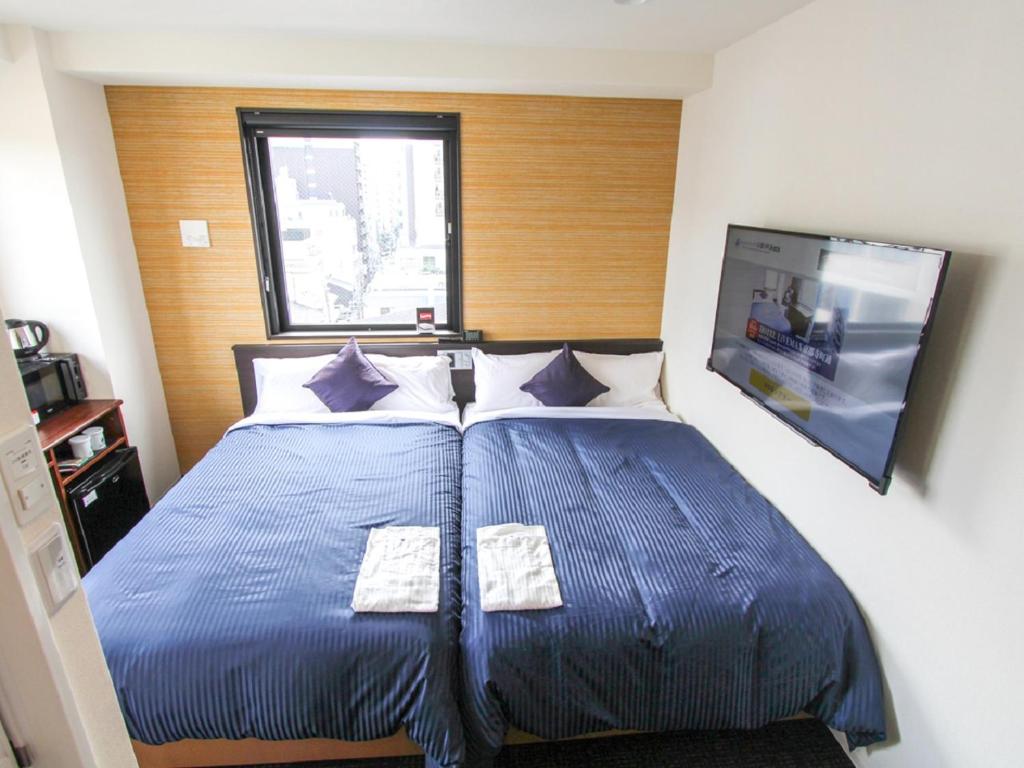 Postel nebo postele na pokoji v ubytování HOTEL LiVEMAX Kyoto Teramachidori