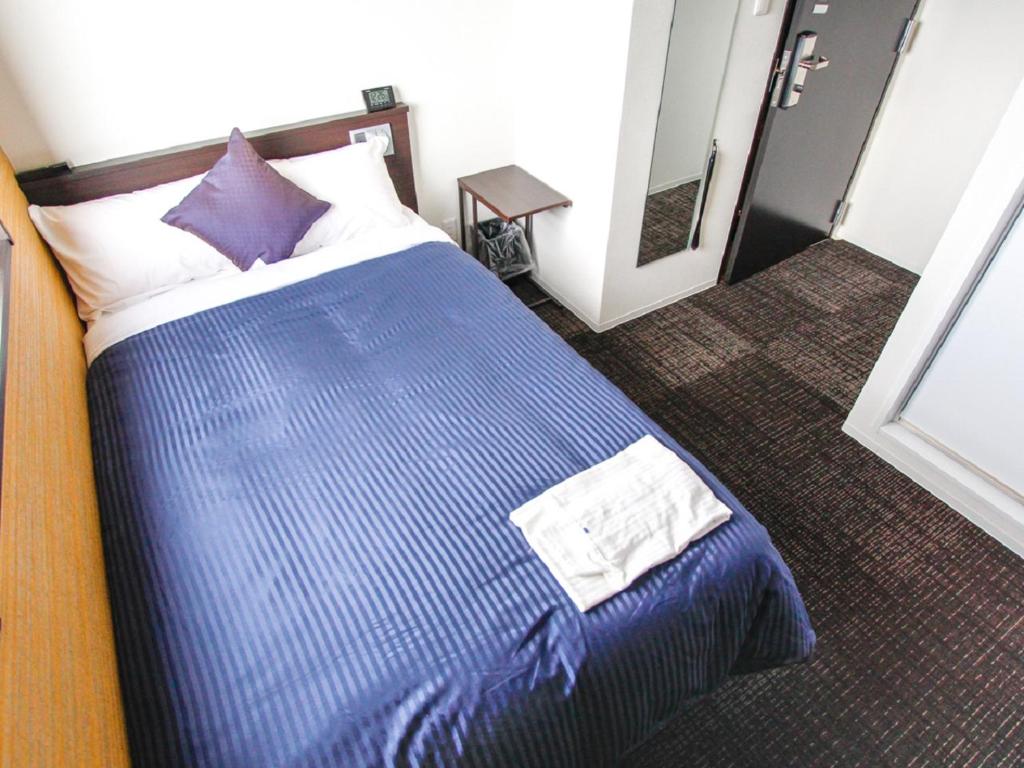 Postel nebo postele na pokoji v ubytování HOTEL LiVEMAX Kyoto Teramachidori