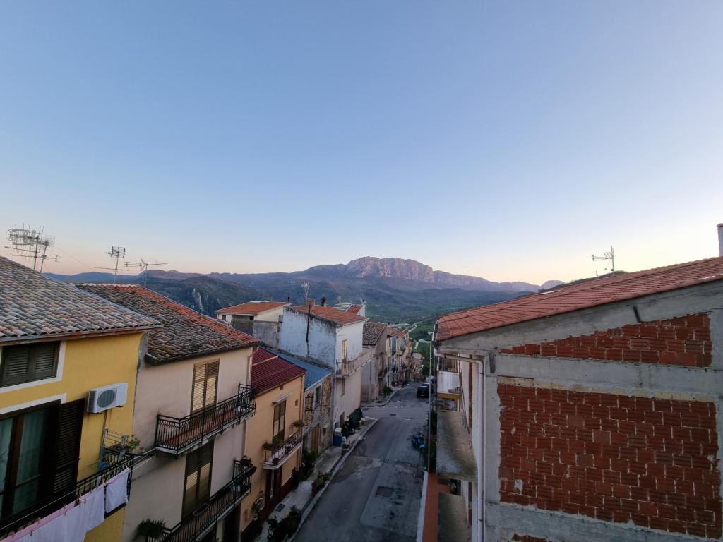 a city street with buildings and mountains in the background at Casa di Mamma in Godrano